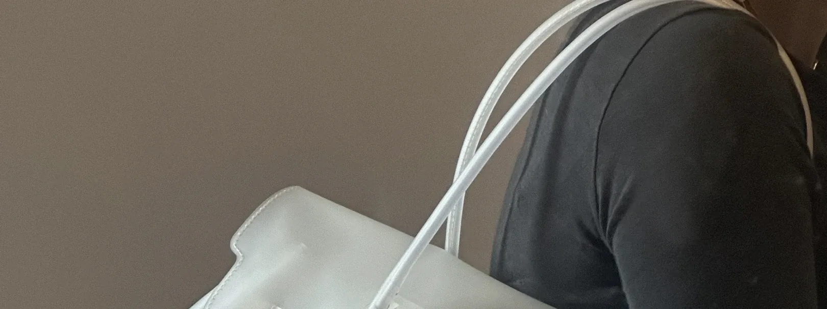 frosted clear jelly tote carried on the shoulder, with rolled clear handles